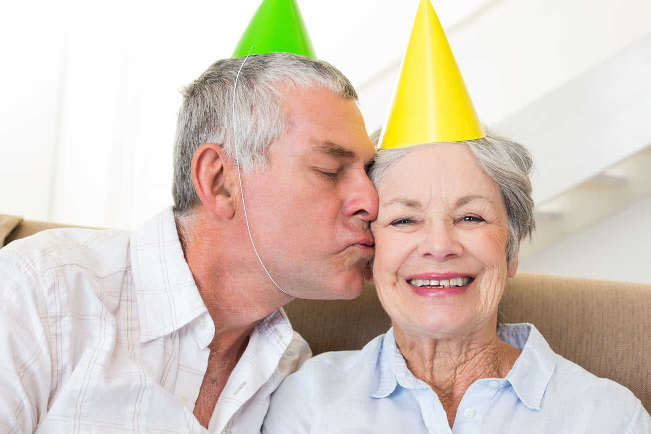 Elderly couple wearing party hats