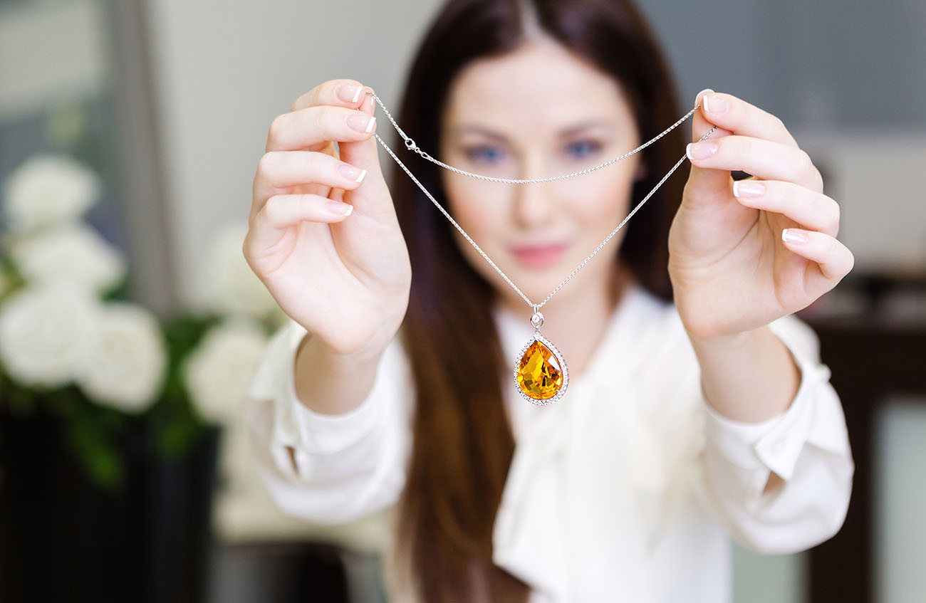 Woman carrying yellow sapphire necklace